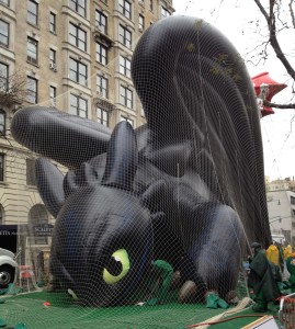 A balloon version of How to Train Your Dragon character Toothless being held down