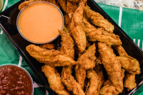 A basket of chicken fingers with dipping sauce