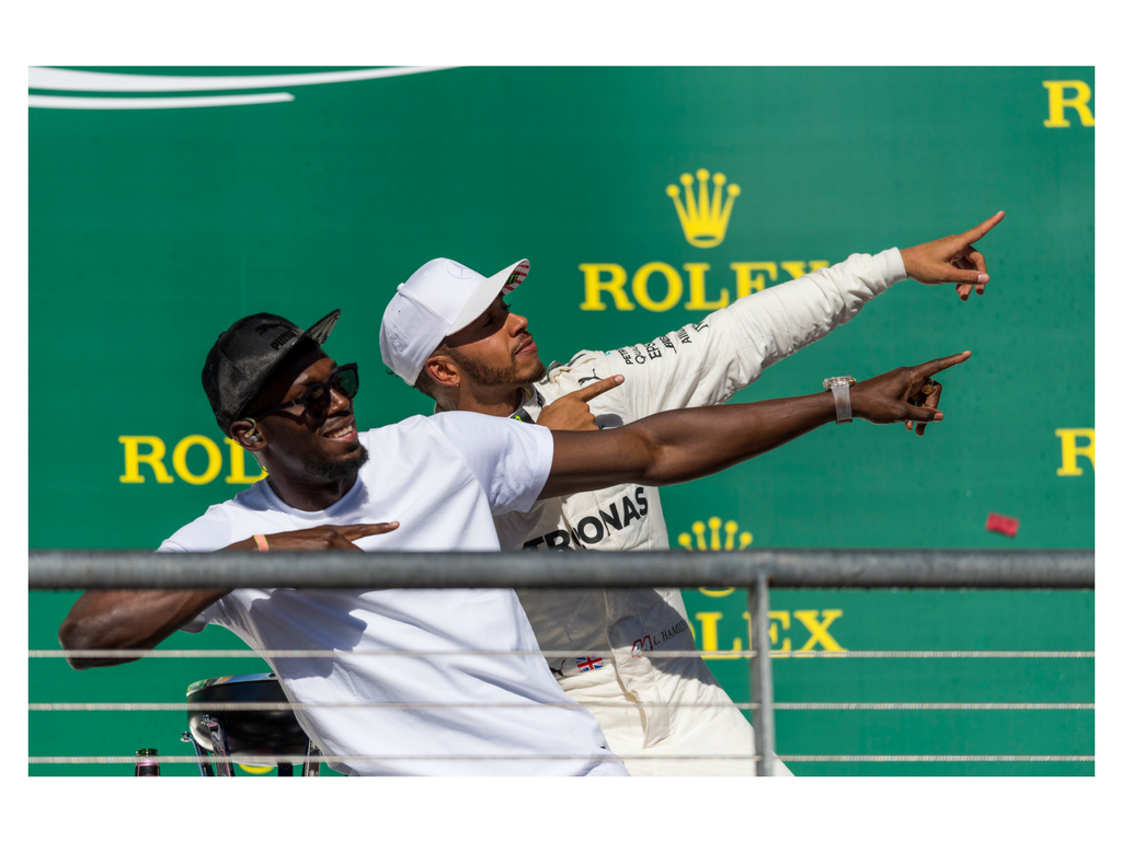 British driver Lewis Hamilton and Jamaican sprinter Usain Bolt strike the iconic "Lightning Bolt" pose in celebration of Hamilton's win.