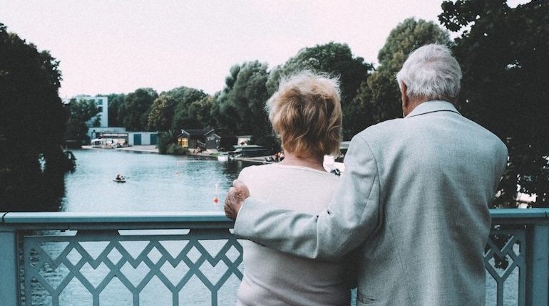 visualhunt.senior couple embracing on bridge e1561407124985