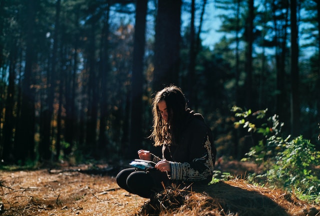 a woman journaling in a forest